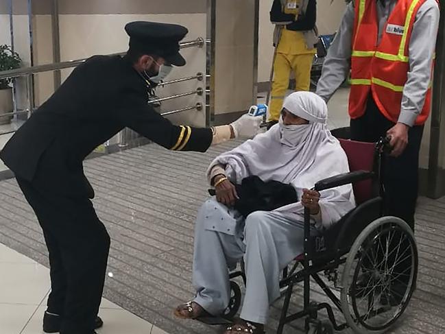 An airport official checks the temperature of a passenger upon his arrival at the Bacha Khan International Airport in Peshawar. Picture: STR/AFP