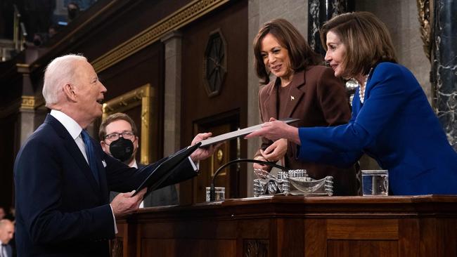 Joe Biden hands a copy of his state-of-the union speech to Nancy Pelosi as Kamala Harris looks on. Picture: AFP