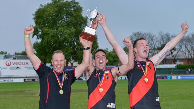 Tea Tree Gully coach Justin Maschotta, co-captains Chad Schoenmakers and Blake Penney celebrate winning the 2020 division two grand final, which was played at Norwood Oval. Picture: Brenton Edwards