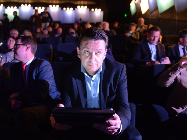 Nick Xenophon checks results on a tablet at the post-election party at the Palace Nova Cinema in Adelaide. Picture: AAP Image/Brenton Edward