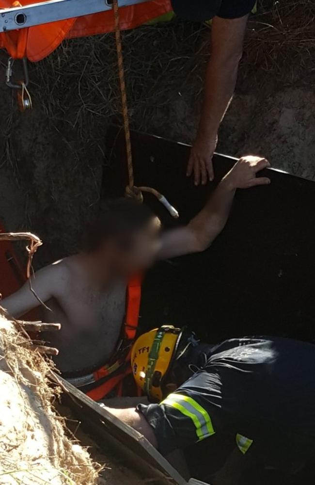 Emergency services work to free the man stuck in the sinkhole. Picture: Queensland Police Service