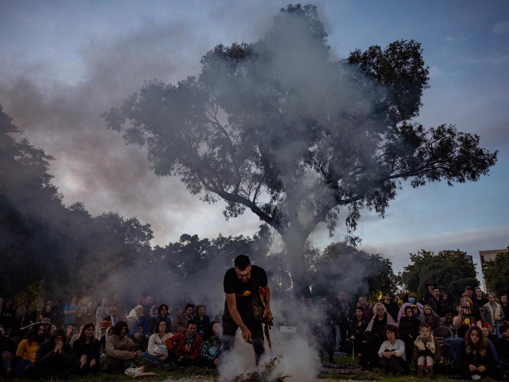 A man stoked the smoke of a fire during the Invasion Day Dawn Service in Melbourne, as crowds gathered to mark the occasion. While Australia Day celebrates the arrival of the First Fleet in 1788, many Indigenous Australians observe the day as ‘Invasion Day,’ calling for a change of date to better reflect the history of all Australians. Picture: Getty