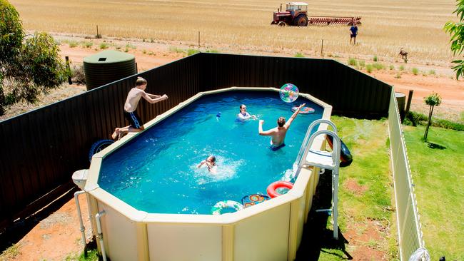 Mildura wheat farmer Daniel Fox cooled off on a scorcher of a 43C day with his children by taking a much-needed dip in their family pool. Daniel headed home to soak up the sun with his children, Claudia, 6, Hannah, 10, Tom, 11 and Sam, 13. Picture: Jason Edwards