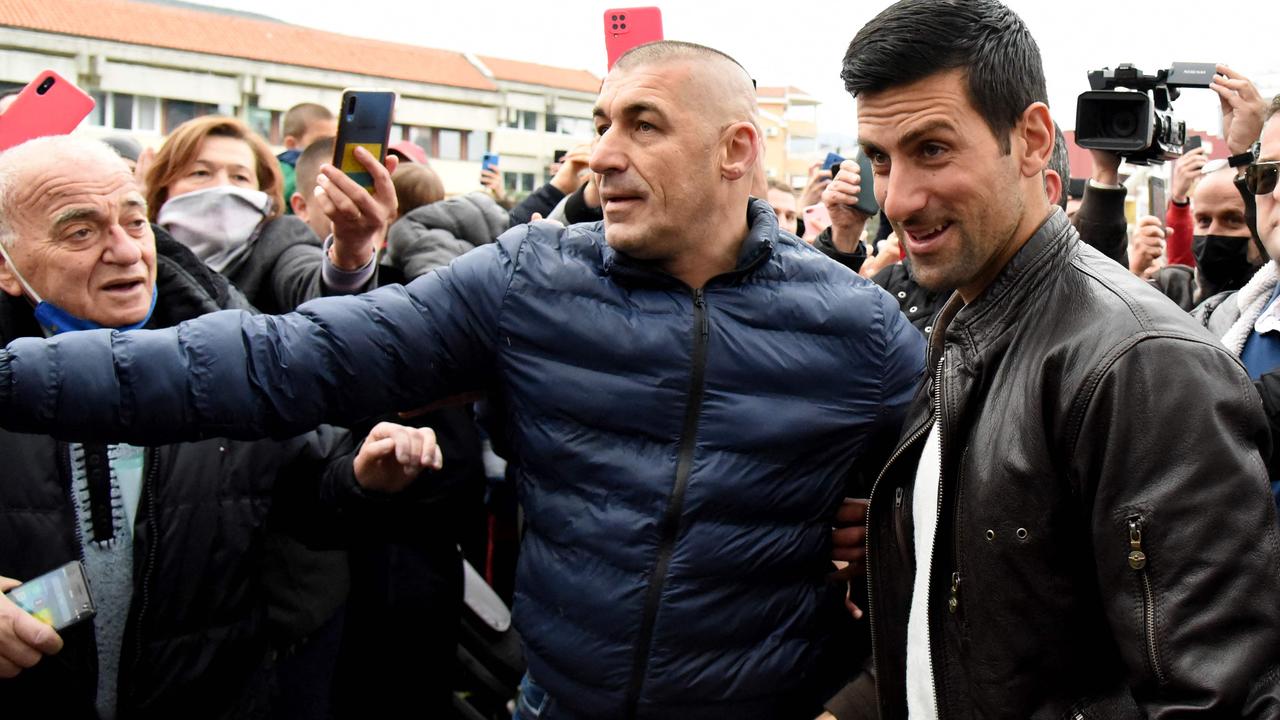 Serbian tennis player Novak Djokovic walks surrounded by fans as he arrives for a ceremony in the coastal city of Budva on January 28, 2022. (Photo by SAVO PRELEVIC / AFP)