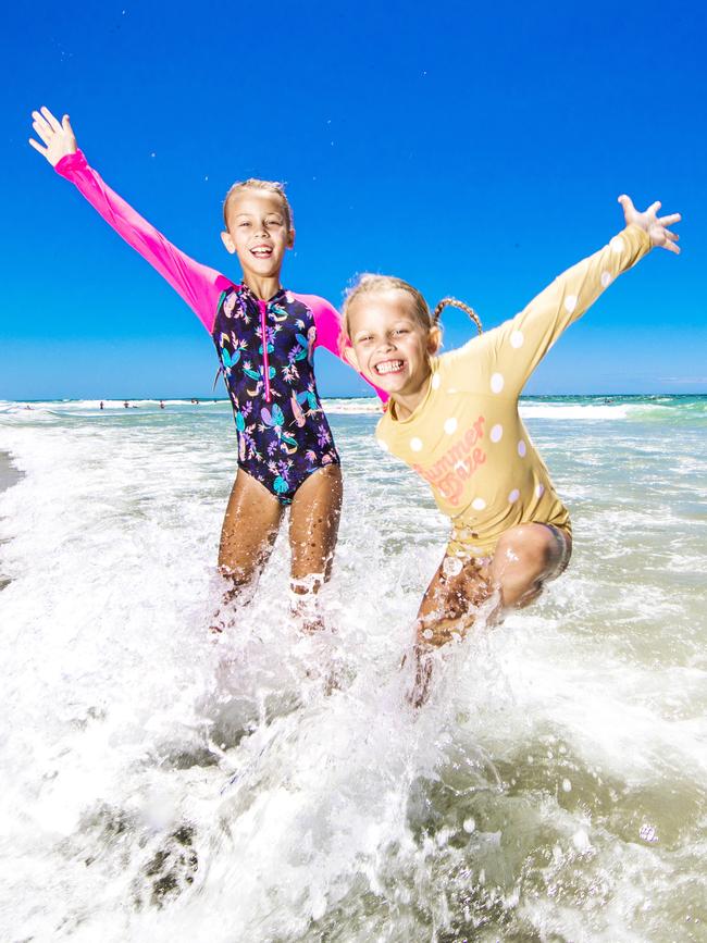 Sienna McDonald, 8, and her sister Harper, 6, from Mudgeeraba, cool off at Tugun beach. Picture: Nigel Hallett