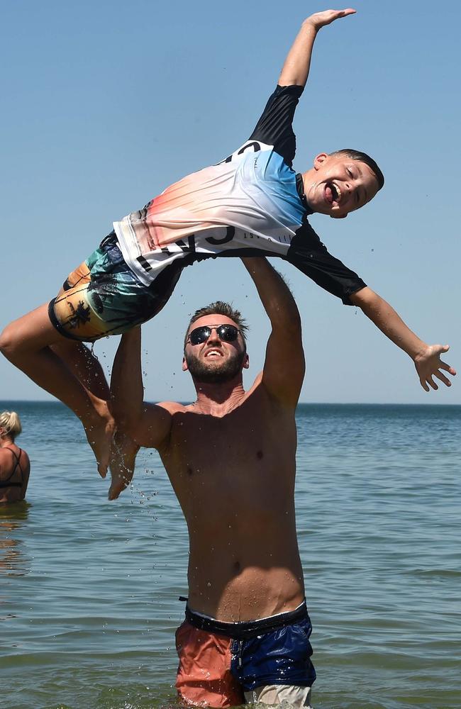 Ryan Davidson takes a dip with his 10-year-old son, Joey. Picture: Nicole Garmston