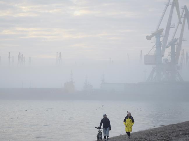 A couple walks on a beach near the port of Berdyansk on the Azov Sea on February 16. Picture: Getty Images