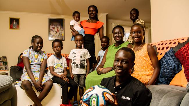 Jok Akuien, 15, holding a soccer ball, with the 10 members of his household in Adelaide (AAP Image/ Morgan Sette)