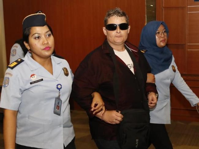 Renae Lawrence being escorted through Bali airport.