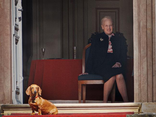 Queen Margrethe could be seen sitting down enjoying a glass of bubbly as her pooch sunned herself in the doorway. Picture: Ritzau Scanpix / AFP / Denmark OUT