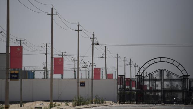 Chinese flags on a road leading to a facility believed to be a re-education camp where mostly Muslim ethnic minorities are detained, on the outskirts of Hotan in Xinjiang. Picture: AFP.