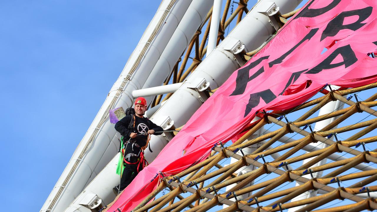 A man clings to a spire to protest delayed climate action. Picture: NCA NewsWire / Nicki Connolly