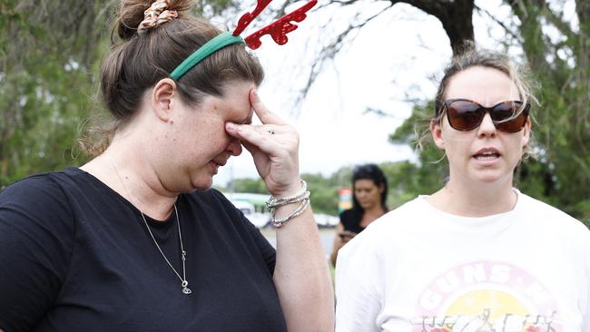 Shae Curr-Parkes and Kate Hammacott wait for word from family members stranded by flood waters at Holloways Beach. Flood water from ex Tropical Cyclone Jasper has caused major flooding in Cairns, Far North Queensland. Picture: Brendan Radk