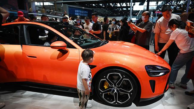 A child looks at a Xiaomi SU7 at the Beijing Auto Show in Beijing last month. Picture: AFP