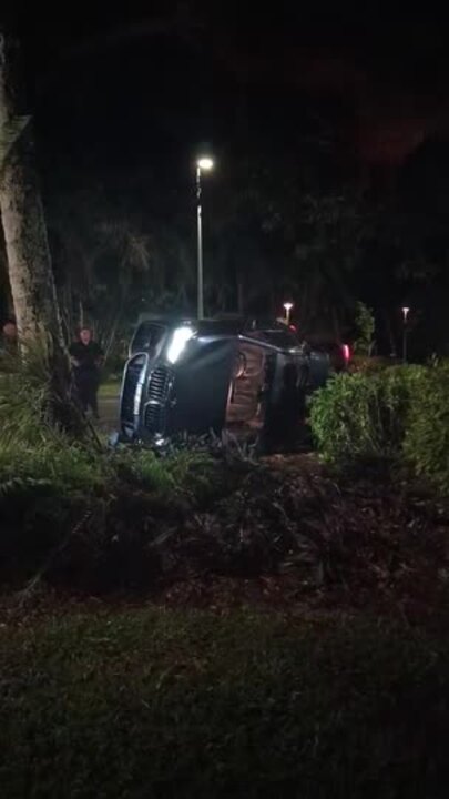 Woman fined after BMW flips on busy street, nearly hits tree