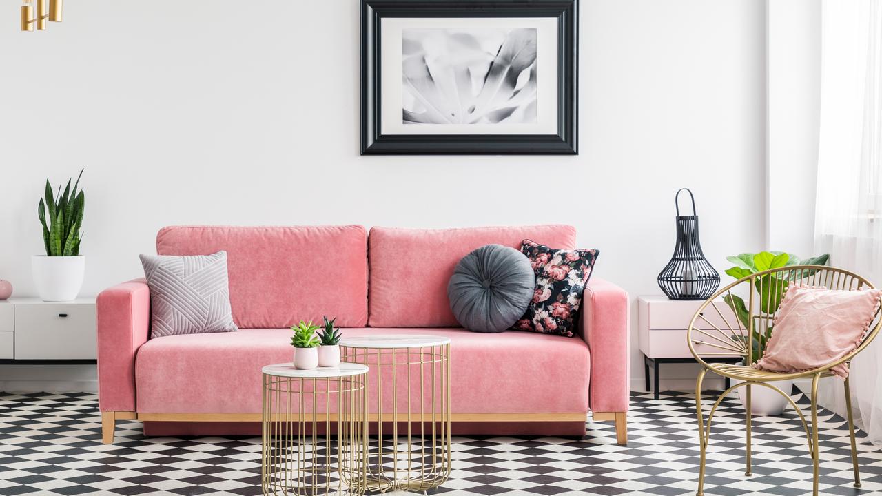 Glamour living room interior with a pink sofa, golden armchair and tables, painting and checkered tiles. Picture: iStock