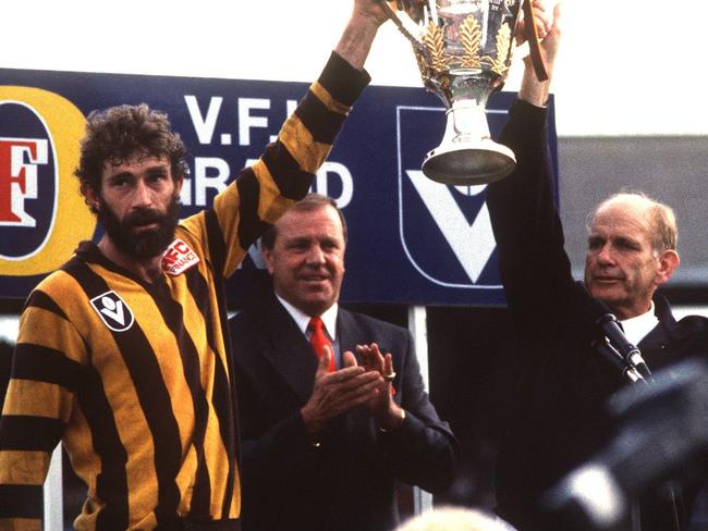 1989 AFL Grand Final. Hawthorn v Geelong. MCG. Captain Michael Tuck and coach Allan Jeans with the premiership cup. Ted Whitten in background. Colour. Color.