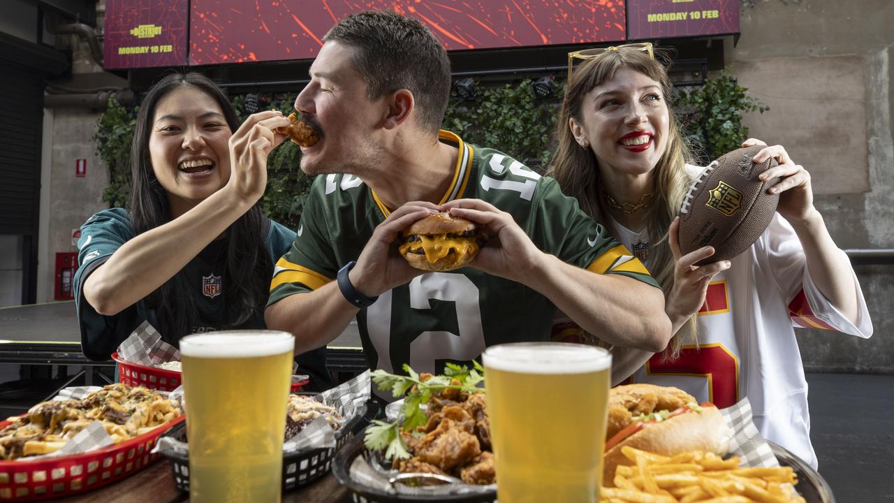 Zach Stewart enjoying a chicken wing with Ronnie Young, 30, and Maree Ellard, 30, at The District at SkyCity ahead of Monday's Super Bowl. Picture: Brett Hartwig