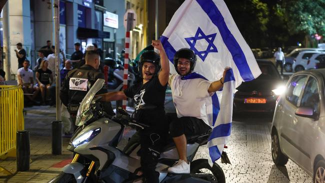 People cheer and wave an Israeli national flags as they celebrate the news of the death of Hamas leader Yahya Sinwar, in the Israeli costal city of Netanya, on October 17, 2024. Picture: AFP