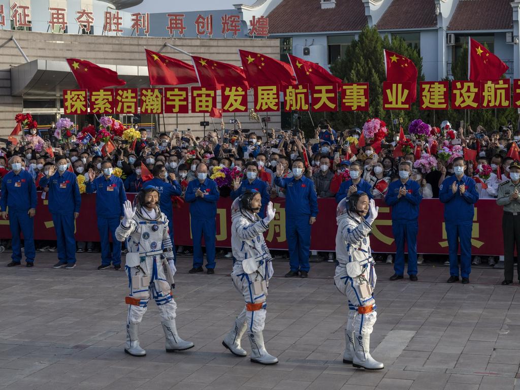 Chinese astronauts and crew of the Shenzhou-16 (from left) Gui Haichao Zhu Yangzhu and mission leader Jing Haipeng wave to wellwishers at a pre-launch departure. Picture: Getty Images