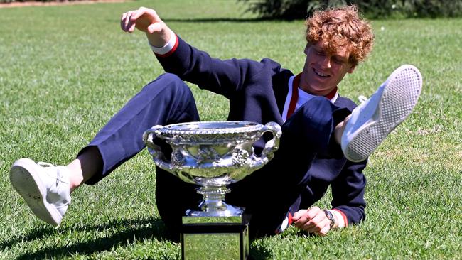 Italian Jannik Sinner makes himself comfortable with the Norman Brookes Challenge Cup trophy at the Royal Botanic Gardens in Melbourne on Monday after his Australian Open victory. Picture: AFP