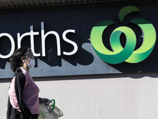 SYDNEY, AUSTRALIA - AUGUST 17: A woman in a surgical mask walks past the entrance to the Woolworths Metro supermarket in North Strathfield on August 17, 2020 in Sydney, Australia. New South Wales remains on high alert as new COVID-19 cases continue to be diagnosed. Customers of the Supermarket are being urged to watch for symptoms after a person who has tested positive for COVID-19 case visited the store over the weekend. The state recorded seven new cases of COVID-19 in the last 24 hours with six locally-acquired and one in hotel quarantine. (Photo by Brook Mitchell/Getty Images)