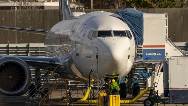 A worker stands under a Boeing 737 MAX at the company's Renton production facility in Washington. Picture: AFP