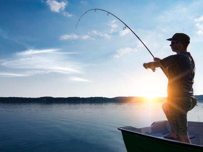 fishing rod lake fisherman men sport summer lure sunset water outdoor sunrise fish - stock image