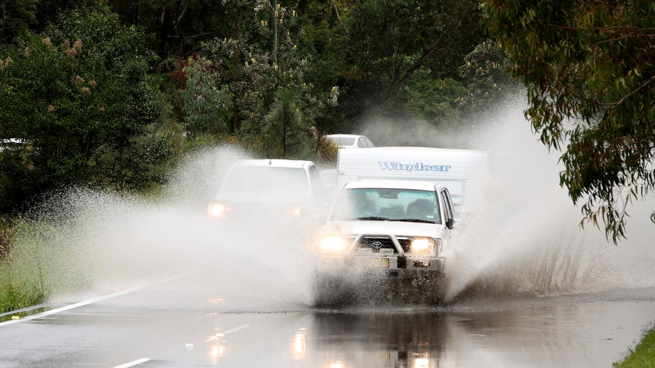 A 4WD and caravan drive through a flooded part of Forest Way in Belrose. Picture: NewsWire / Damian Shaw
