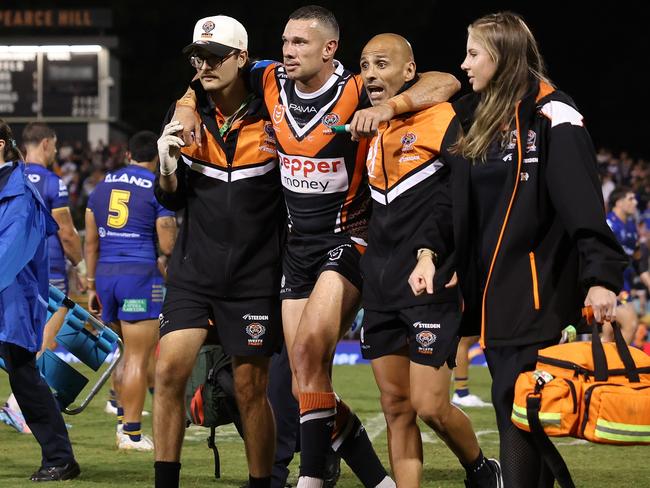 SYDNEY, AUSTRALIA - FEBRUARY 21:  Brent Naden of the Wests Tigers is assisted off the field after a knee injury during the 2025 NRL Pre-Season Challenge match between Wests Tigers and Parramatta Eels at Leichhardt Oval on February 21, 2025 in Sydney, Australia. (Photo by Mark Metcalfe/Getty Images)