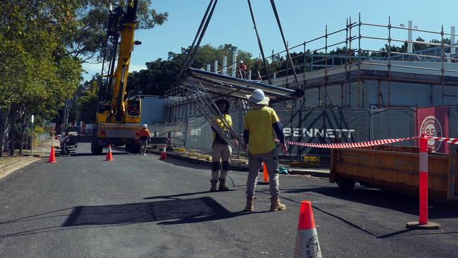 A crane delicately removing the old solar heating tubes from the roof.