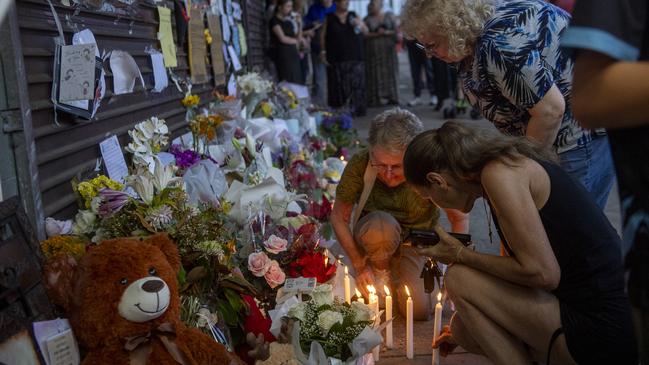 Community members pay out candles at the memorial for the much-loved couple. Picture: Jeremy Piper