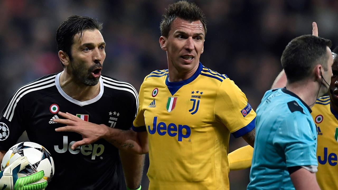 Juventus' Italian goalkeeper Gianluigi Buffon (L) argues with the referee