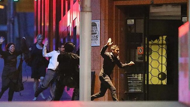 People run with their hands up from the Lindt Cafe, Martin Place. Picture: Getty Images