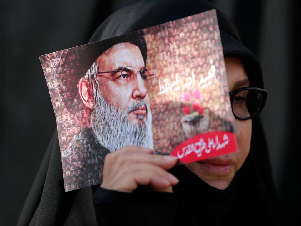 A woman holds up an images of Lebanon's Hezbollah chief Hassan Nasrallah during a rally at a stadium in Beirut. (Photo by Ahmad Al-Rubaye / AFP)
