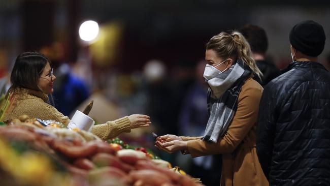 People are seen wearing masks at the Queen Victoria Market on Saturday. Picture: Daniel Pockett