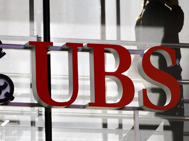 (FILES) In this file photo taken on October 30, 2012 an employee walks past a logo of the Swiss banking giant UBS in Zurich. - The national financial prosecutor condamnes UBS on November 8, 2018 to a fine of 3.7 billion euros for illegally and conscientiously approaching wealthy French customers, and hiding billions of undeclared assets. The trial of UBS at the Criminal Court of Paris for orchestrating a large tax fraud system continues until November 15, 2018. (Photo by Fabrice COFFRINI / AFP)