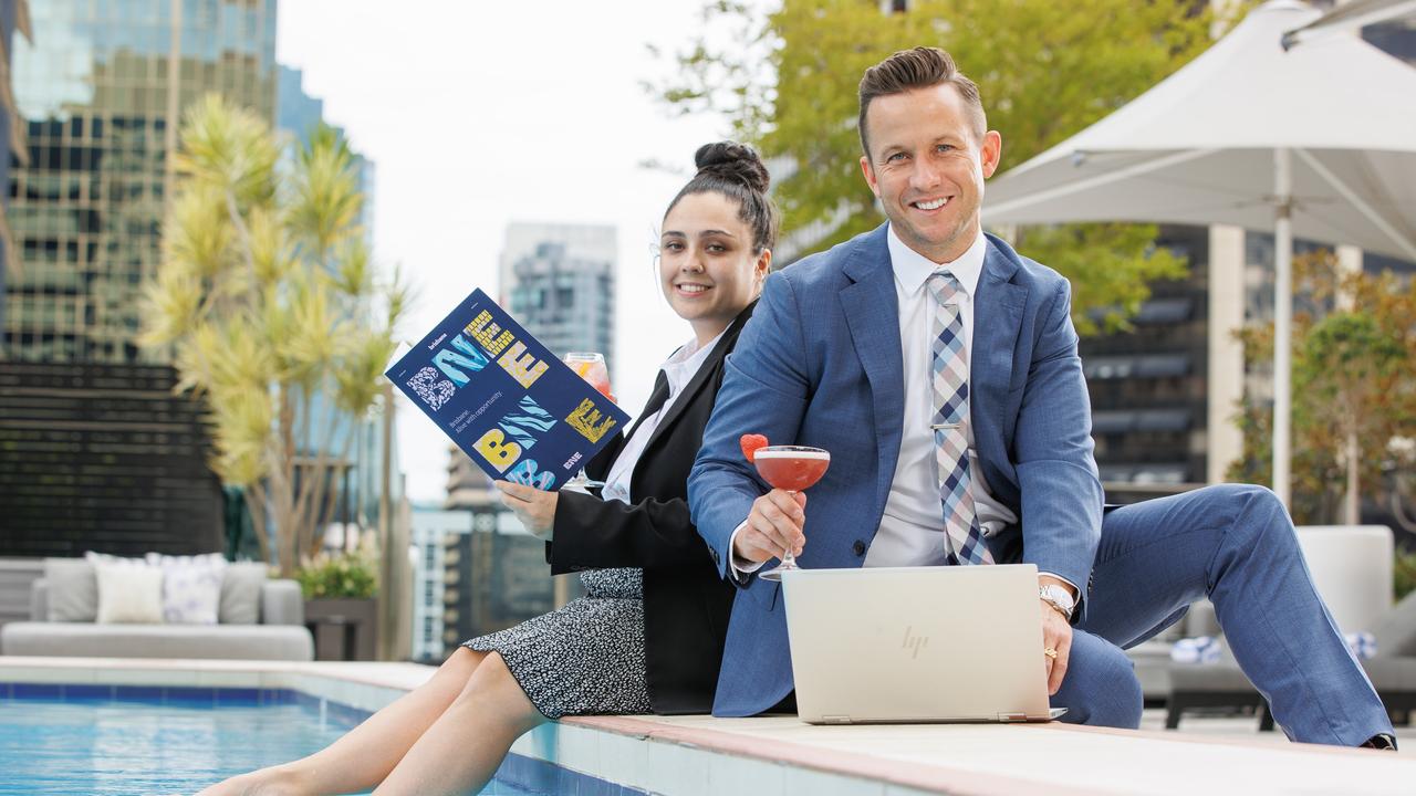 Naomi Hussein and Steve Goodall enjoy working by the pool at the Sofitel Hotel while on business in Brisbane. Picture: Lachie Millard