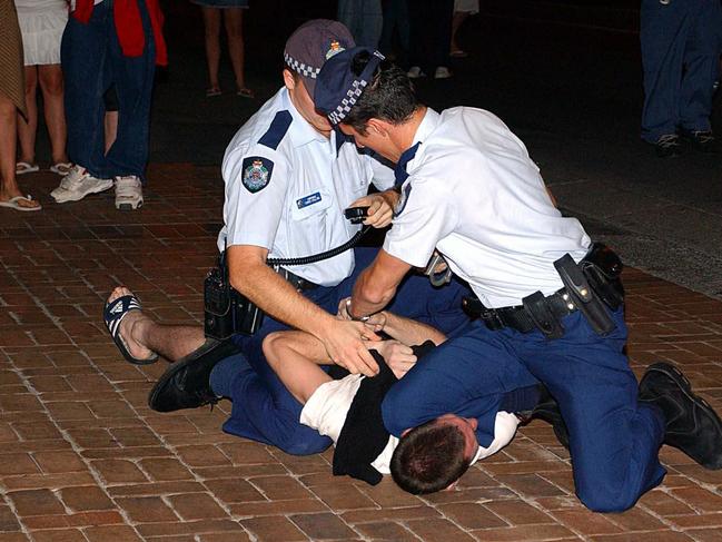 Police arrest a youth troublemaker in 2002.