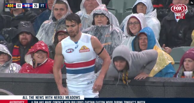 Crows fan touches Bulldogs captain Easton Wood.