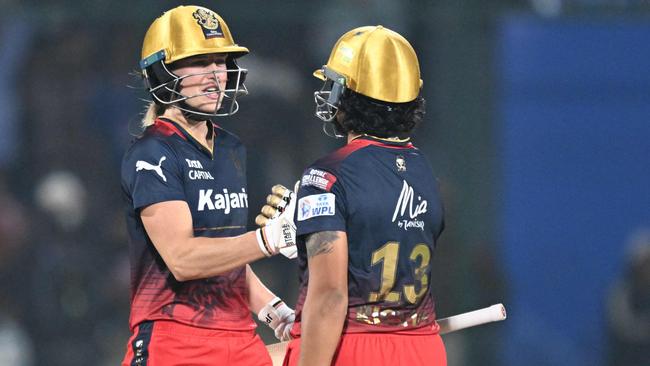 Royal Challengers Bangalore's Richa Ghosh (R) celebrates with Ellyse Perry after winning the Women's Premier League (WPL) Twenty20 cricket final match between Royal Challengers Bangalore and Delhi Capitals at the Arun Jaitley Stadium in New Delhi on March 17, 2024. (Photo by Sajjad HUSSAIN / AFP) / -- IMAGE RESTRICTED TO EDITORIAL USE - STRICTLY NO COMMERCIAL USE --