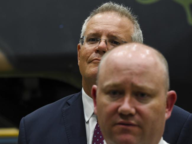 Scott Morrison listens to RFS Commissioner Shane Fitzsimmons speak to the media during a visit to HMAS Albatross in Nowra on Sunday. Picture: AAP/Lukas Coch