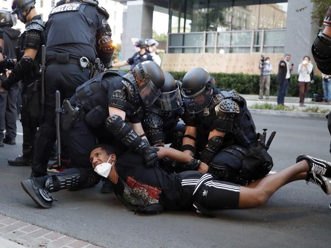 A demonstrator is taken into custody by police after a curfew took effect during a protest over the death of George Floyd near the White House in Washington. Picture: AP