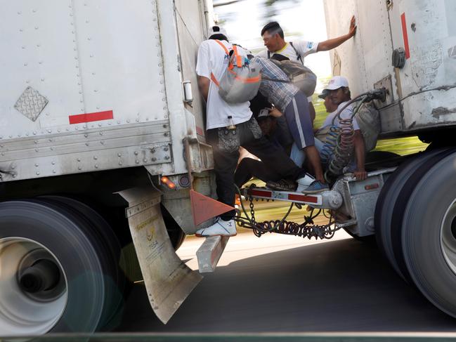 Migrants, part of a caravan of thousands from Central America en route to the United States, hitchhike on a truck along the highway to Mapastepec from Huixtla, Mexico, October 24, 2018. REUTERS/Ueslei Marcelino - RC1FACB93220