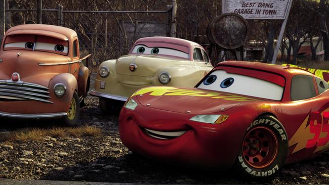 Lightning McQueen (right, voiced by Owen Wilson) comes hood to hood with other vehicles in Cars 3.