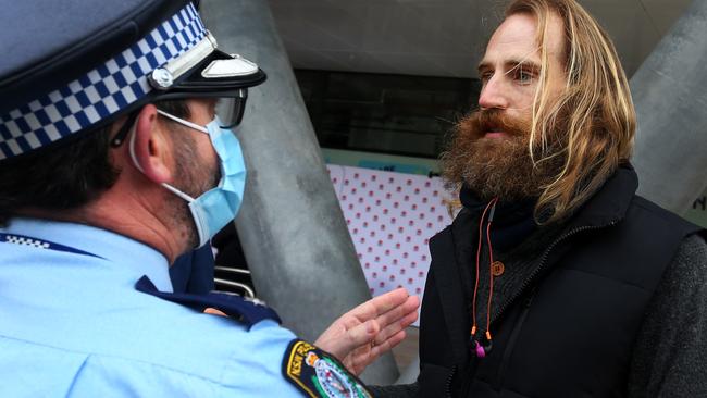 The ‘prime creator’ is removed by police after disrupting a COVID-19 update and press conference with NSW Premier Gladys Berejiklian and state leaders. Picture: Getty Images.