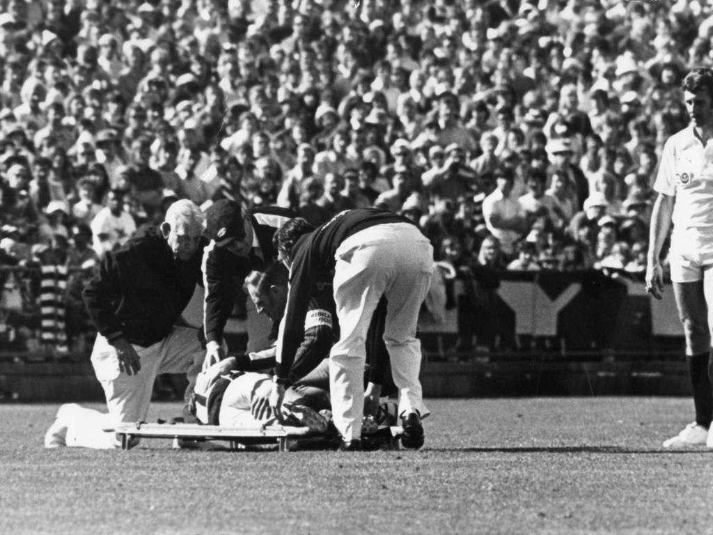 Trainers lift injured Kym Kinnear onto a stretcher in the 1977 grand final. Picture: Bryan Charlton)