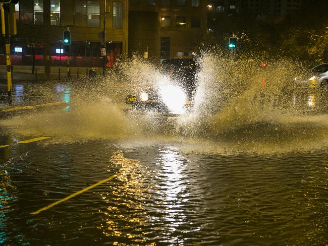 A jeep 4WD splashes through flooding at the intersection of Eddy and Pitt St in Sydney's CBD. Photo: Chris McKeen