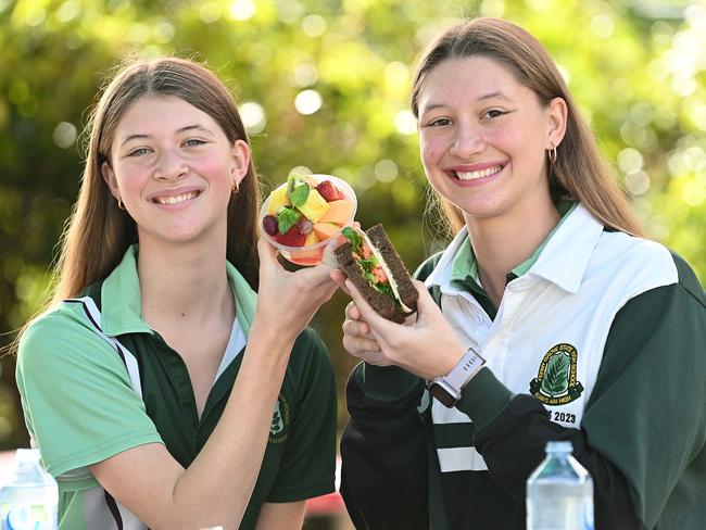 14/07/2023:  Student sisters   (L-R) Hannah 15 and Amber 17 Smyth, at Ferny Grove High School , with sushi, fruit salad, rye salad sandwiches , chicken wraps and water are an example of Queensland school tuck shops are serving healthier items   Brisbane.  pic Lyndon Mechielsen/Courier Mail