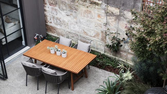 The old sandstone wall gives the courtyard a focal point